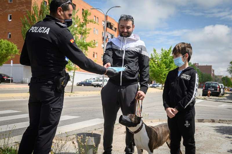 La policía entrega mascarillas a dos personas (Foto: EFE)