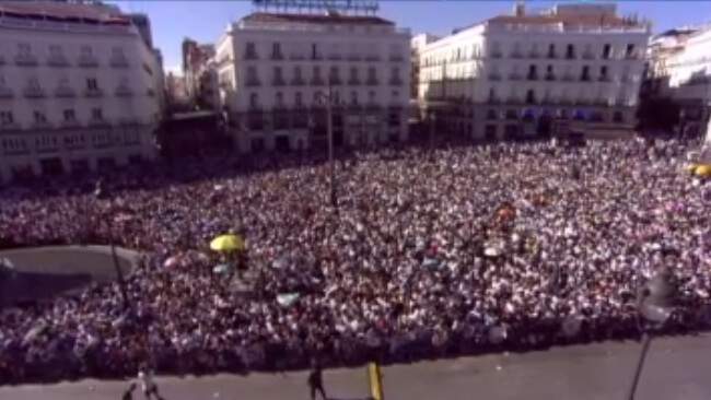 La afición del Real Madrid espera en la Puerta del Sol la llegada de sus ídolos.