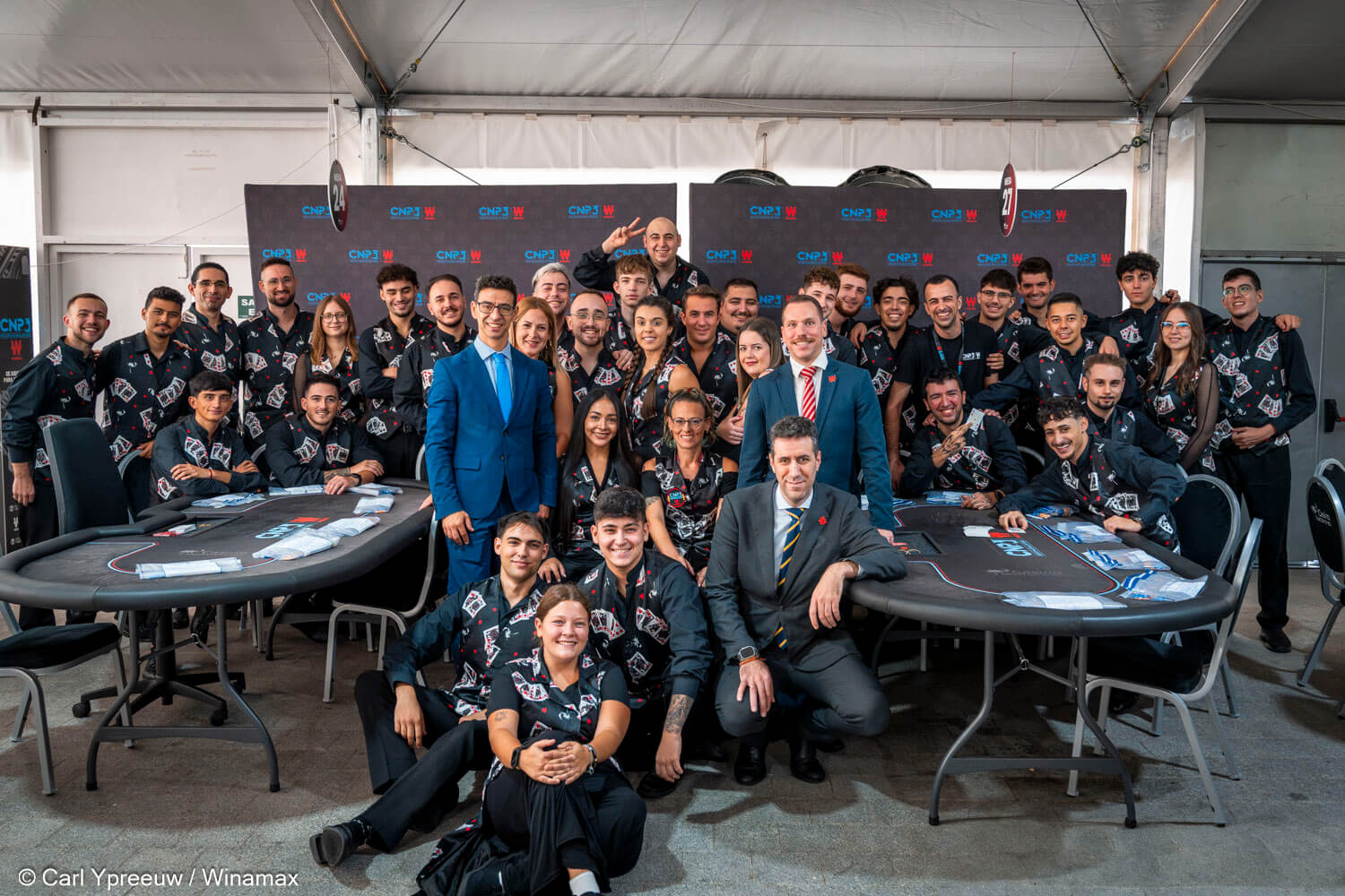 Los crupieres posan junto a los directores del torneo