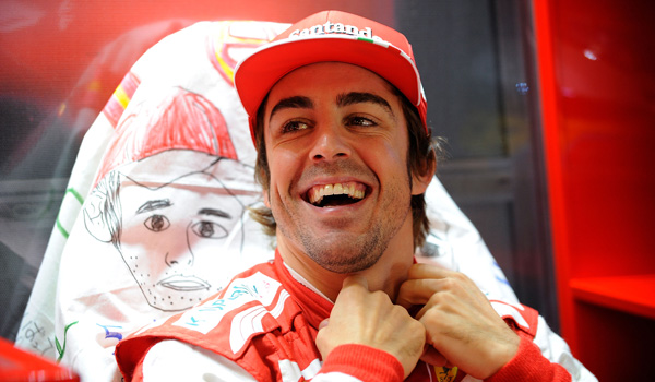 Alonso, sonriendo en el box de su equipo.