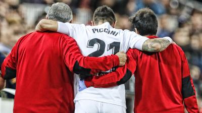 Piccini se marcha lesionado del Valencia-Levante ayudado por los médicos. 