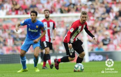 Muniain conduce el balón ante Parejo (Foto: La Liga).