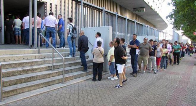 Aficionados del Betis hacen cola en el estadio Benito Villamarín para los abonos.