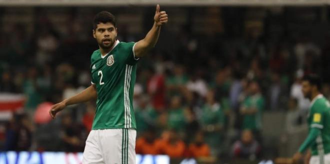 Néstor Araujo levanta el pulgar tras una jugada en un partido con la selección de México.