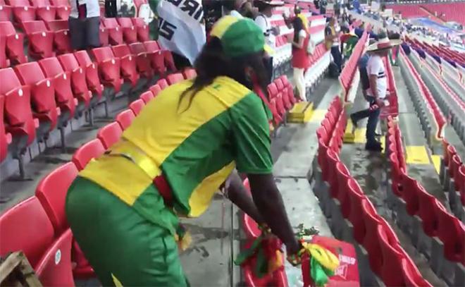 Los aficionados de Senegal recogen la suciedad del estadio tras el Polonia-Senegal.