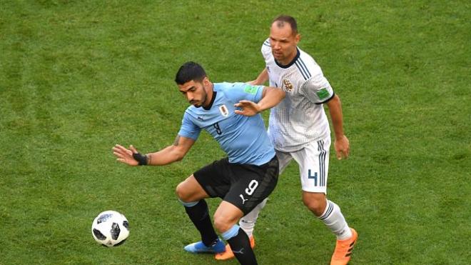 Ignashévich lucha un balón junto al uruguayo Luis Suárez durante la disputa del Uruguay-Rusia en el Mundial.