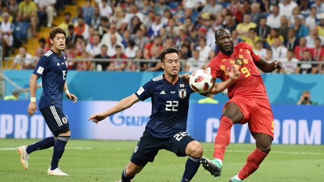 Lukaku y Yoshida pelean por un balón.