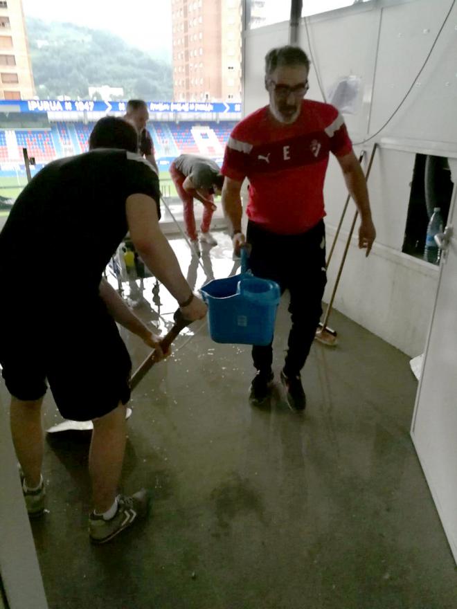 Trabajadores y entrenadores del Eibar sacando agua de la zona de prensa de Ipurua. (Foto: SD Eibar)
