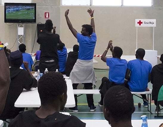 Rescatados del Aquarius, que jugarán al fútbol playa en Valencia, celebran un gol de Senegal durante el Mundial