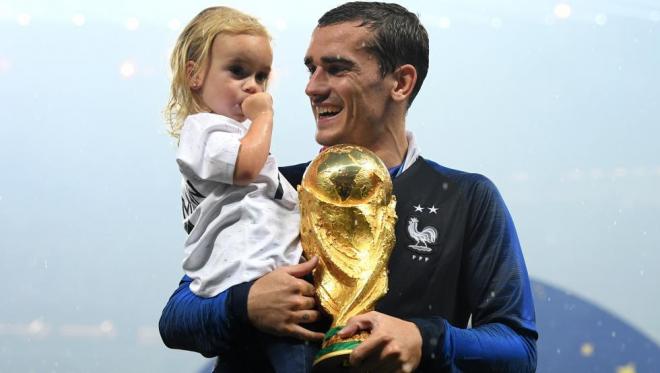Griezmann, junto a su hija, posa con la Copa del Mundo.
