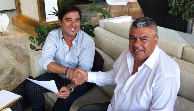Claudio Tapia, presidente de la AFA, estrechándose la mano con Pablo Bombarelli, del Marbella Football Center.