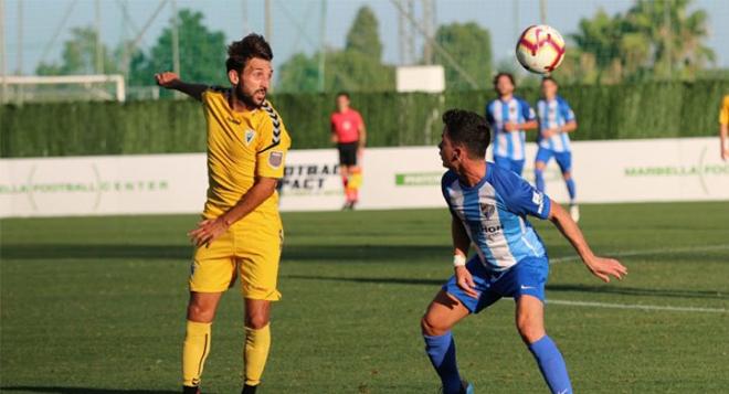 Juanpi, en la disputa de un balón durante el Marbella-Málaga (Foto: Marbella FC).
