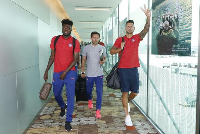 Thomas y Vitolo saludan en su llegada al aeropuerto de Singapur (Foto: Atlético de Madrid).