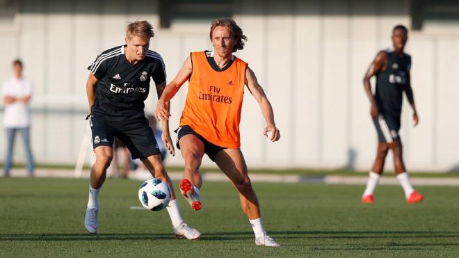 Luka Modric pasa un balón delante de Odegaard en el entrenamiento del 10 de agosto.