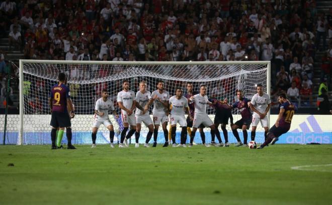 Messi chuta una falta ante la barrera del Sevilla.