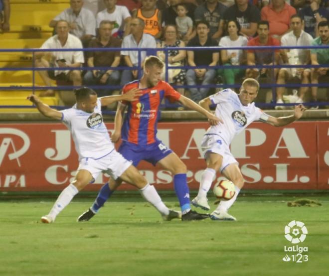 Quique González y Álex Bergantiños intentan robarle el balón a Álex Barrera en el Extremadura-Dépor (Foto: LaLiga Santander).