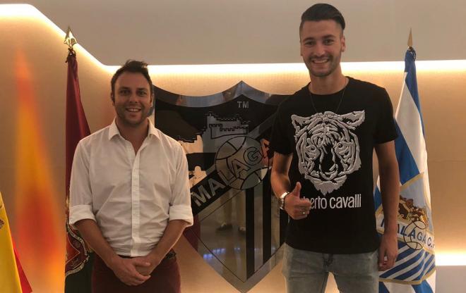 Joel Arimany y su agente, tras firmar su contrato con el Málaga.