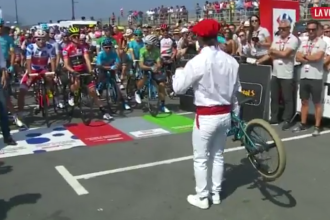 Un dantzari se dispone a bailar un aurresku al pelotón de la Vuelta.