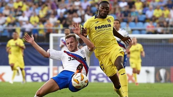 Ekambi y un rival luchan por la pelota.