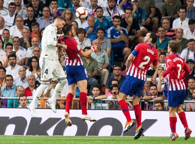 Ramos cabecea un balón con Saúl en el derbi madrileño.