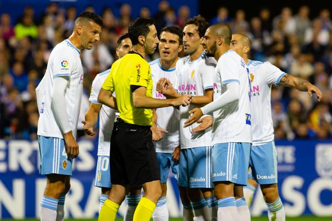 Los jugadores del Real Zaragoza le protestan a Sagués Oscoz el penalti que pitó en el Real Zaragoza-Osasuna (Foto: Dani Marzo).