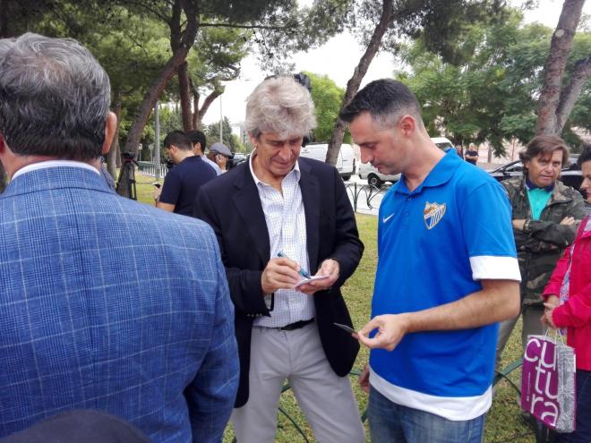 Pellegrini, firmando un autógrafo a un aficionado del Málaga.