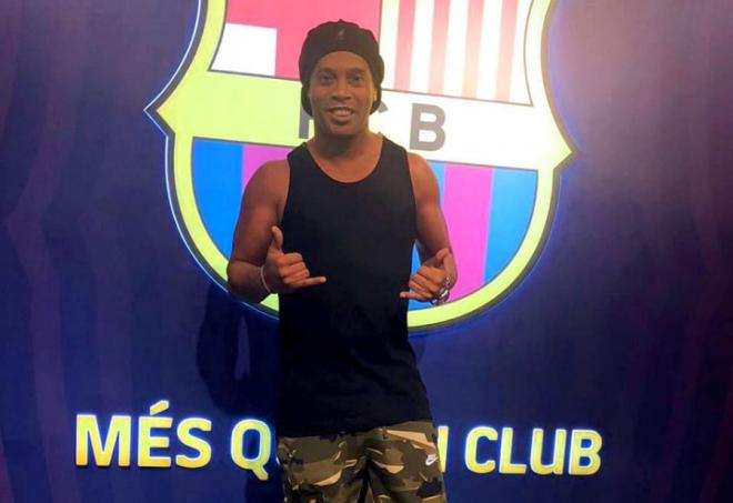 Ronaldinho posa ante el escudo del FC Barcelona.