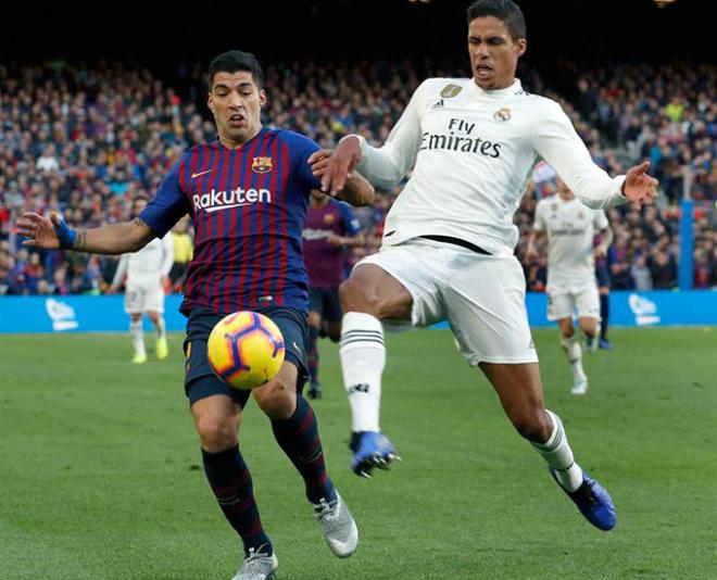 Suárez y Varane luchan un balón durante el Clásico Barça-Real Madrid del Camp Nou.