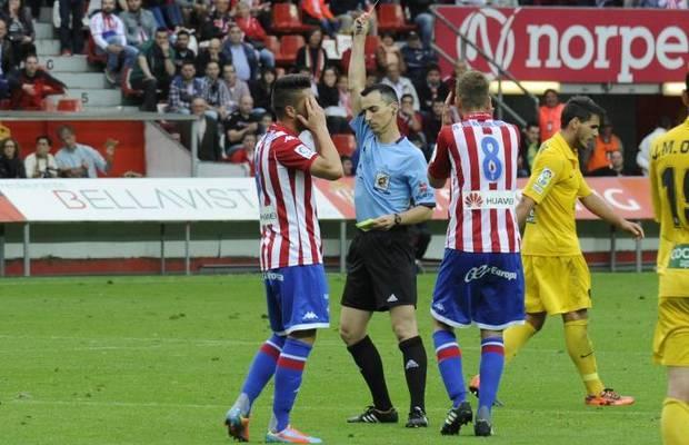 Jaime Latre muestra una cartulina amarilla a Jony en un partido del Sporting.