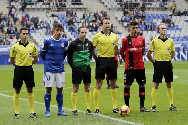 Los capitanes del Real Oviedo y del Mallorca, Saúl Berjón y Xisco Campos, posan junto al árbitro López Toca en el Carlos Tartiere (Foto: Luis Manso).