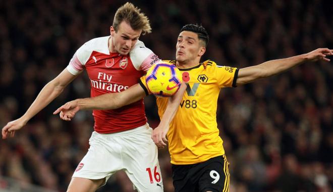 Rob Holding y Raúl Jiménez pelean un balón en el Arsenal-Wolves.