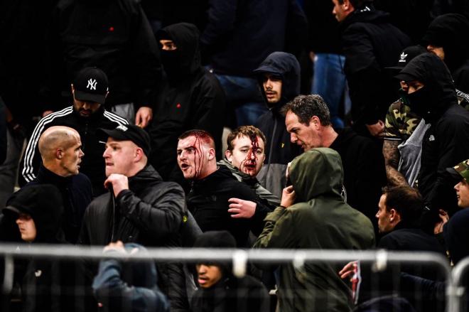Ultras del AEK lanzan bengalas a los hinchas del Ajax.