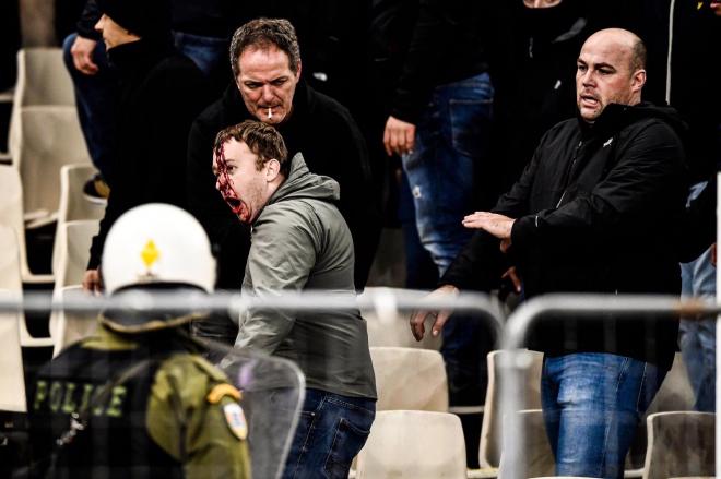 Ultras del AEK lanzan bengalas a los hinchas del Ajax.