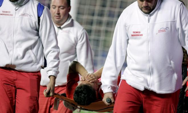 Cristian Ganea se tapa los ojos mientras es retirado en camilla en el Ciutat de València (Foto: EFE).