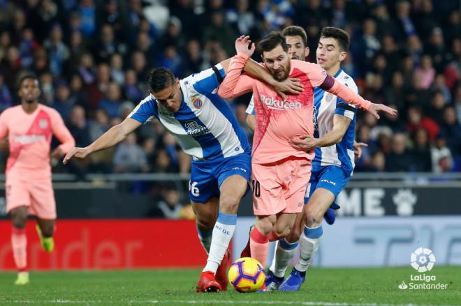 Óscar Duarte y Leo Messi pelean un balón en el Espanyol-Barcelona.