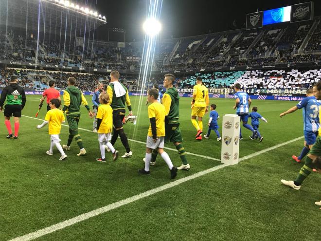 El Málaga y Las Palmas saltan al campo al inicio del partido.