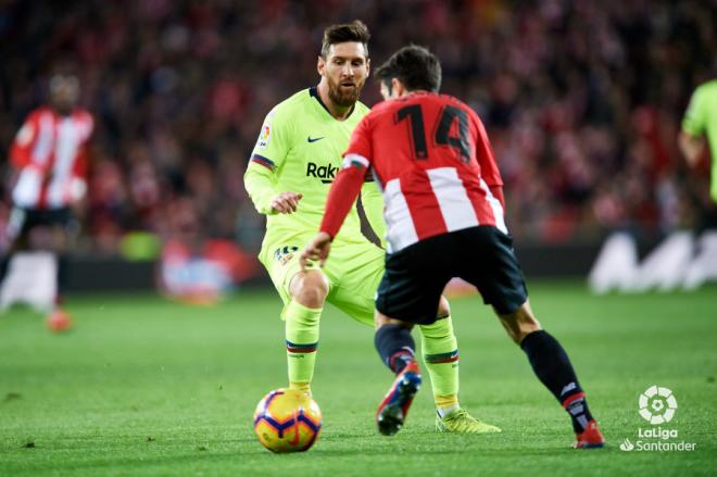 Leo Messi intenta hacerse con el balón ante Markel Susaeta (Foto: LaLiga).