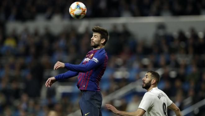 Piqué despeja un balón aéreo delante de Benzema en el Clásico de Copa del Rey.