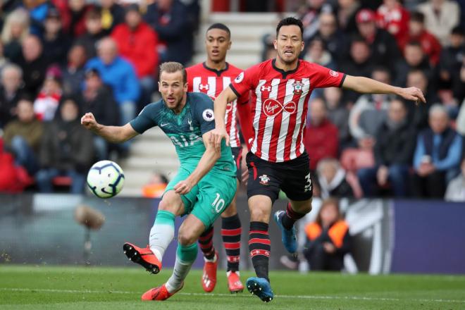 Kane golpea el balón ante Yoshida.