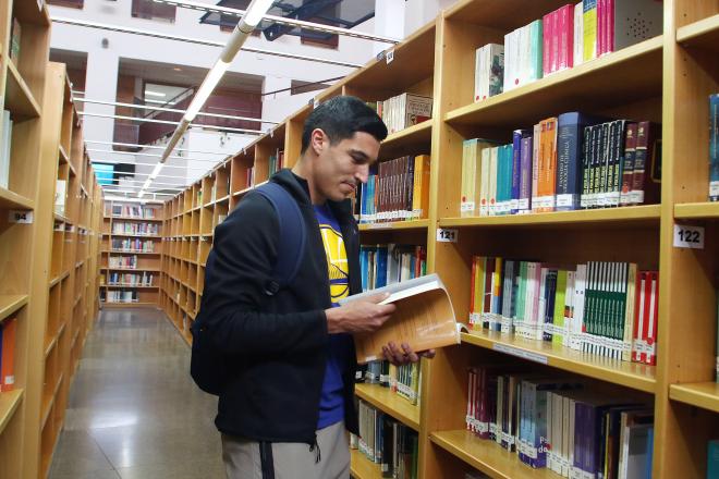 Diego González ojea un libro en la biblioteca del centro (Foto: Paco Rodríguez).