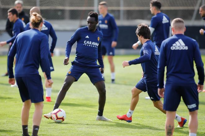 Junior, con balón, y Kike Navarro (de espaldas, con moño), en el entrenamiento del Real Zaragoza (Foto: Daniel Marzo).