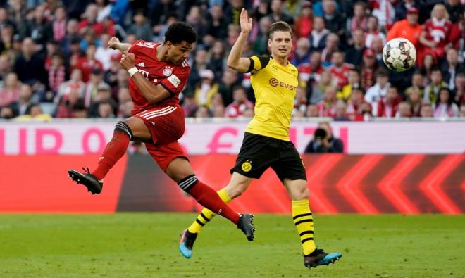 Gnabry remata ante un jugador del Borussia Dortmund.