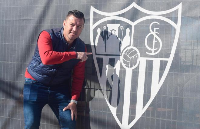 Antoñito junto al escudo del Sevilla FC.