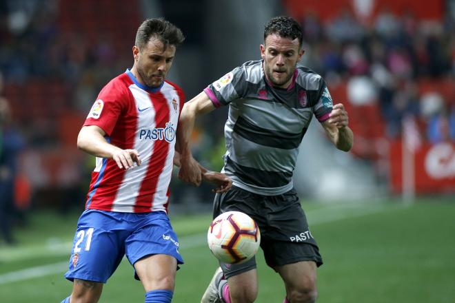 Álex Alegría en una disputa durante el Sporting-Granada en El Molinón (Foto: Luis Manso).