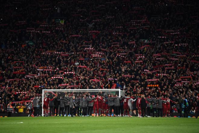 Los jugadores del Liverpool, abrazados mientras escuchan a la afición en Anfield.