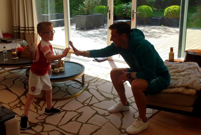 Callum Axford y Mesut Ozil se saludan en la casa del futbolista.