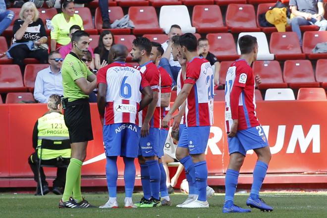 Los jugadores del Sporting piden explicaciones a Vicandi Garrido (Foto: Luis Manso).