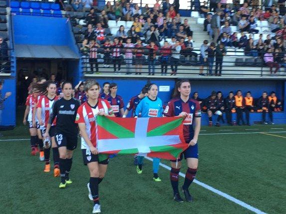 Las capitanas de Athletic y Eibar portan la ikurriña en la salida al campo de Santa Bárbara (Foto: Athletic Club)