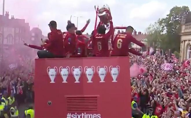 Los jugadores del Liverpool se pasean un autobús abierto por las calles de la ciudad.