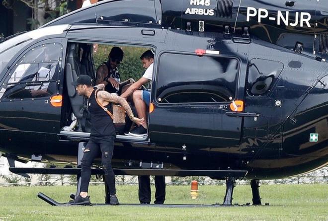 Neymar llega en su helicóptero junto con sus compañeros de la selección brasileña Dani Alves y Thiago Silva al centro de entrenamiento de la Granja Comary.